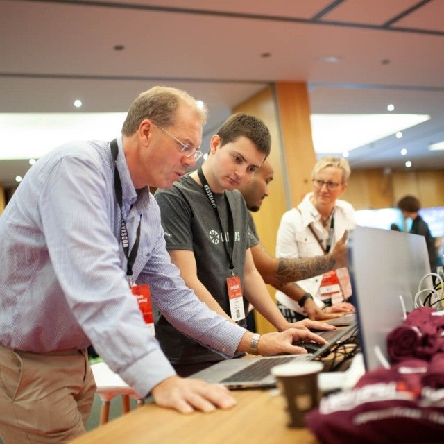 People looking at laptop at event